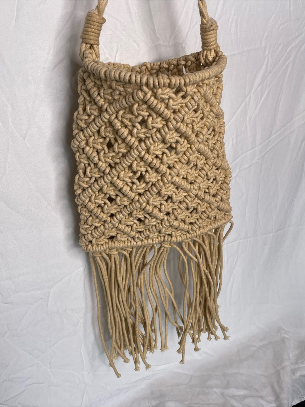 beige boho macrame crossbody bag with a diamond knot pattern and fringe